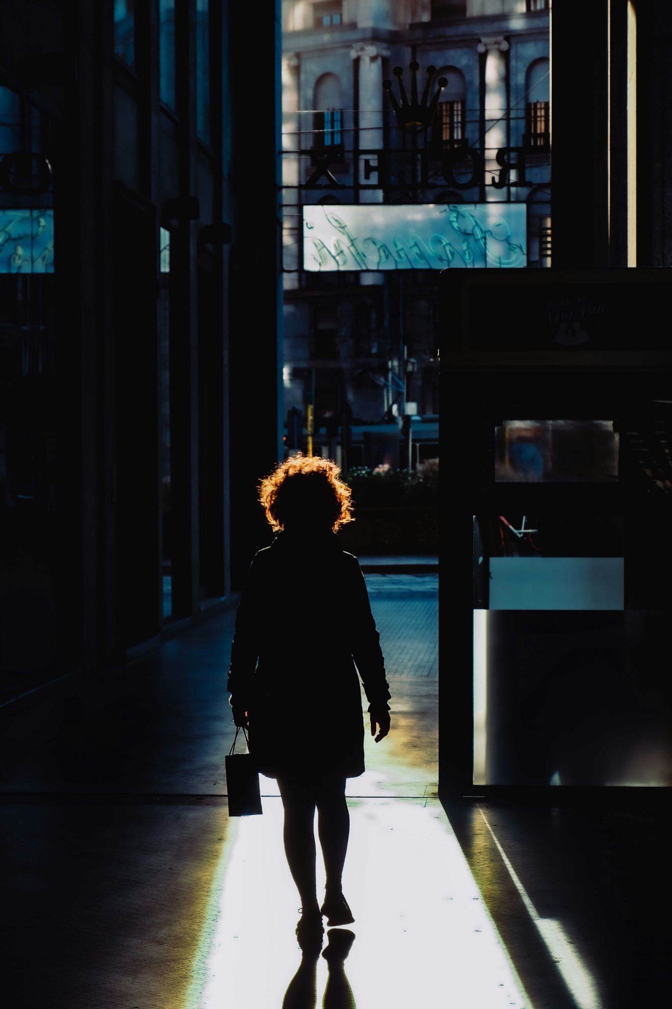 A woman walking towards light.