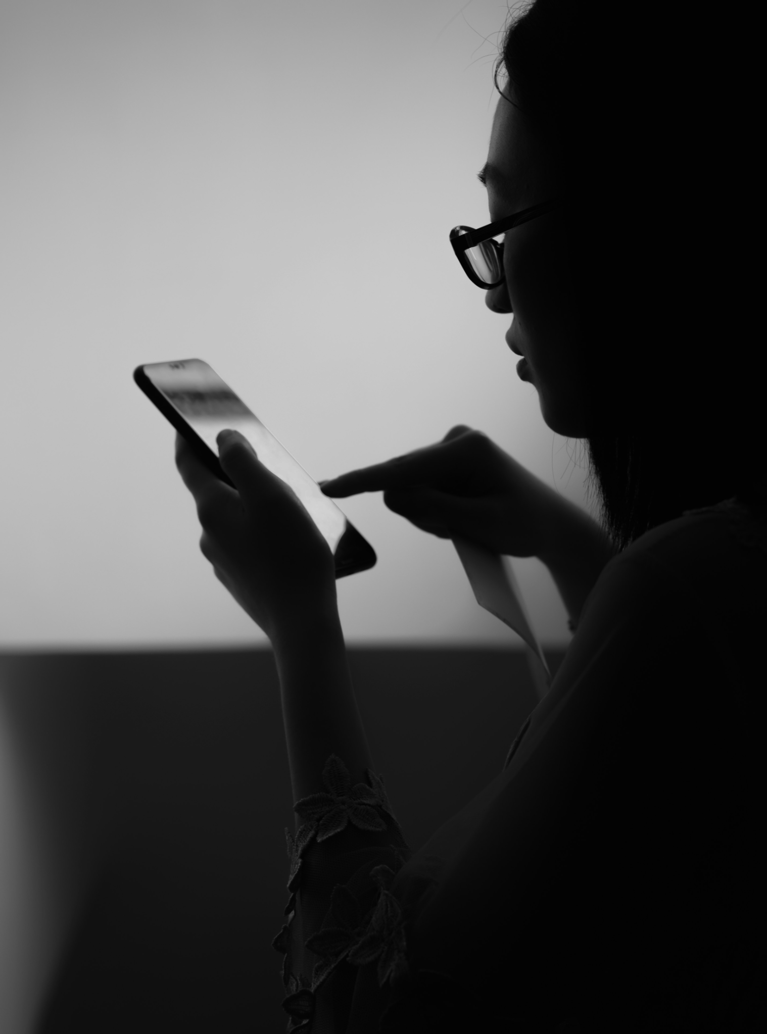 A woman quietly searching for information on her phone.